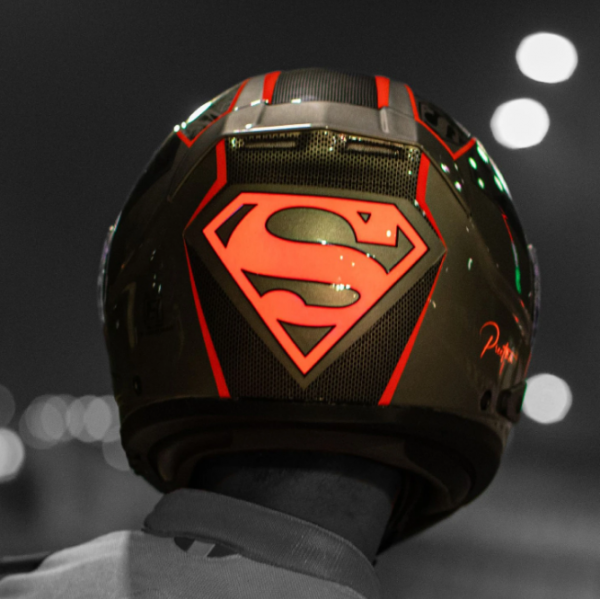 Helm bertema superhero dengan logo dan simbol yang ikonik